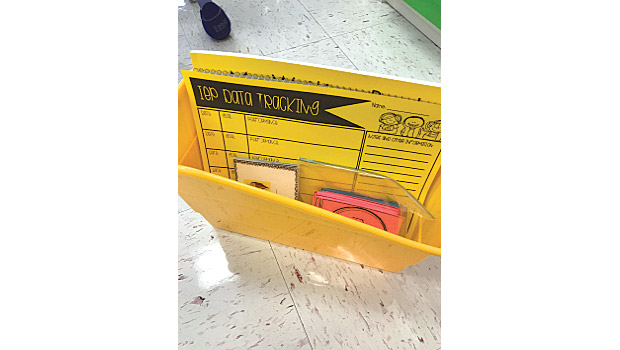 Book bin holding IEP snap shot and sensory items for students in special education classroom.